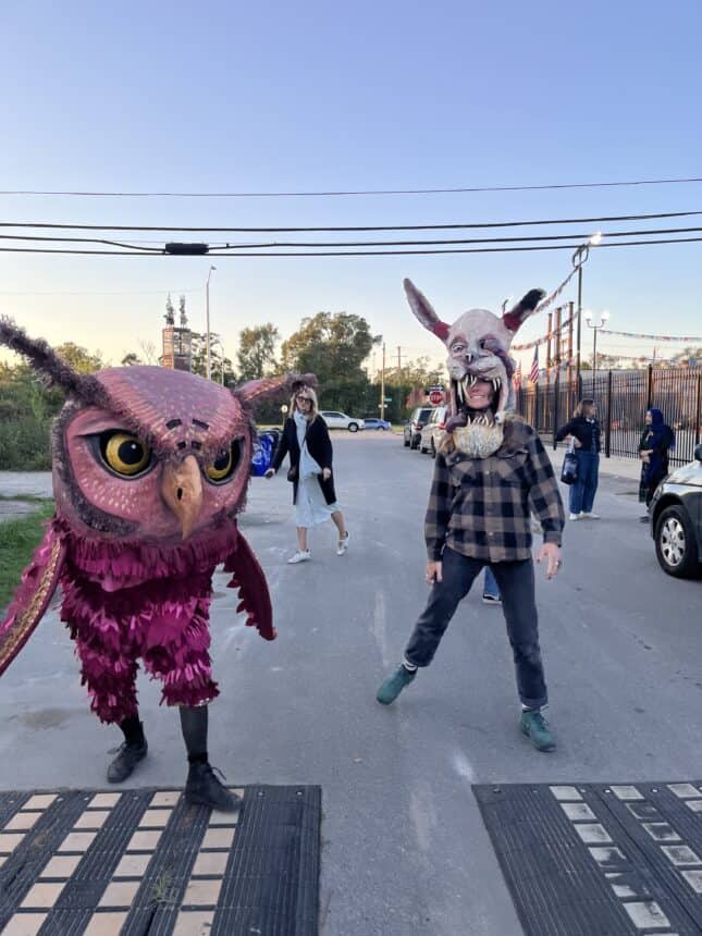 Funny pink owl and another monster strut down the street at the Hamtramck Monster Parade