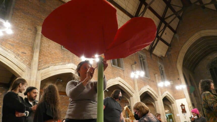 Free Palestine workshop, Lindsay assembles a giant red poppy flower